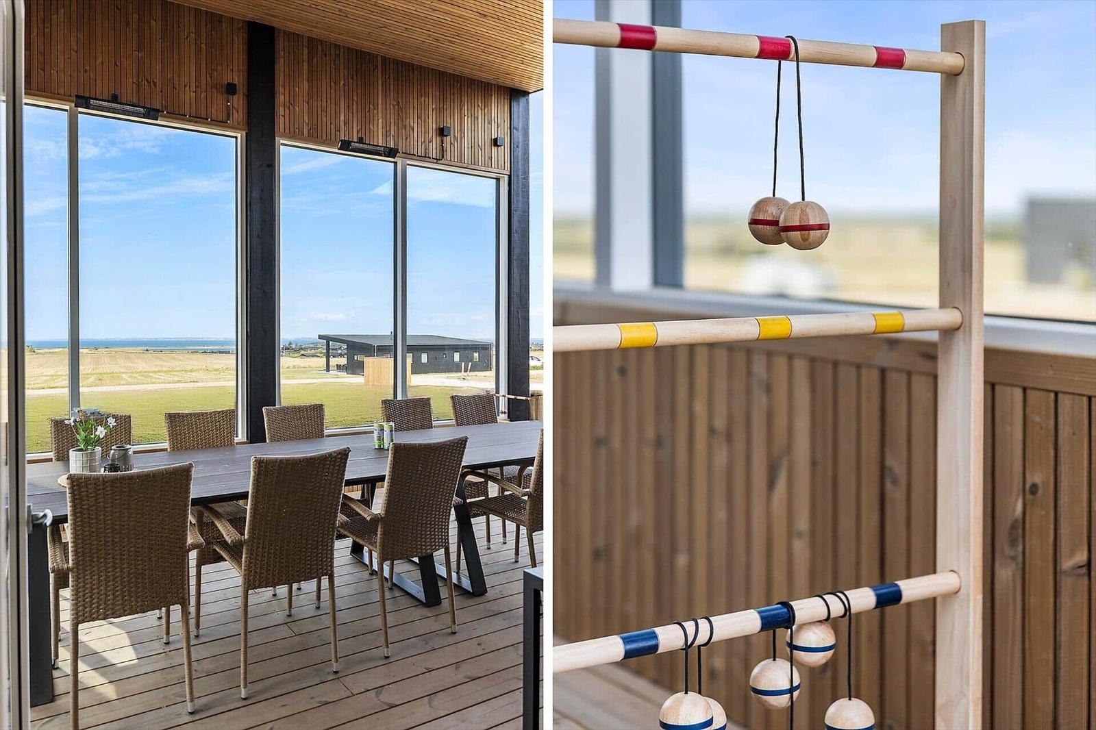 Terrasse mit Esstisch und Stühlen. Holzgeländer und Spielgerät im Hintergrund.
