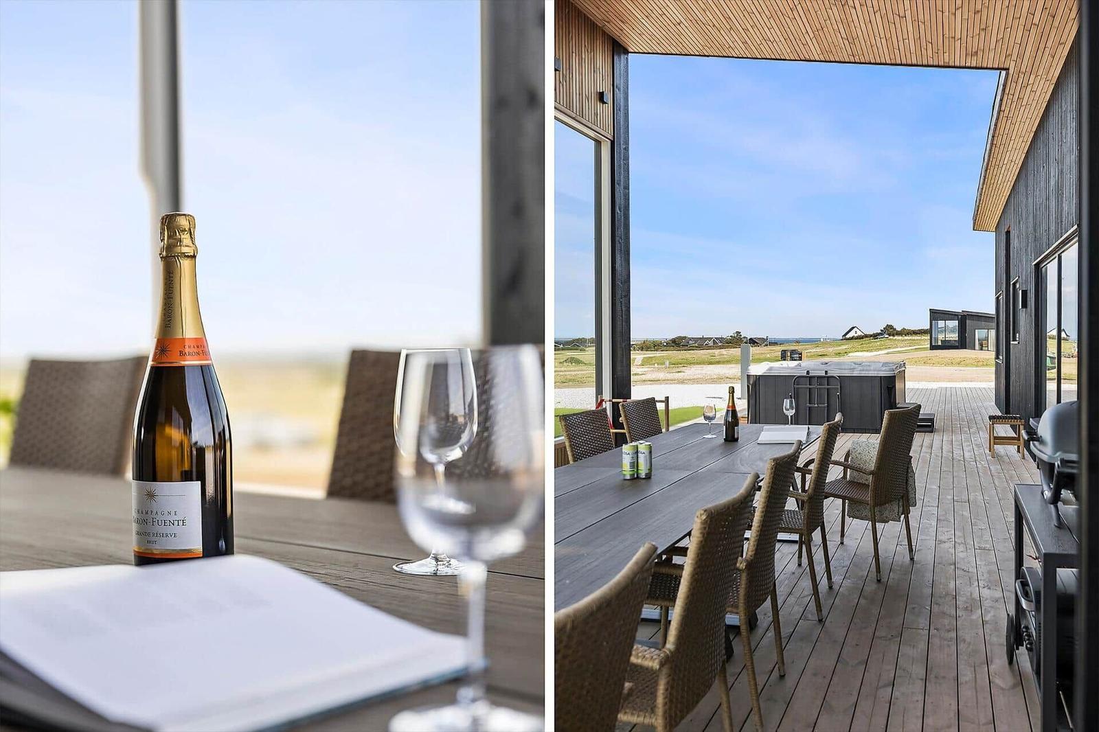 Tisch mit Champagner und Gläsern auf Terrasse mit Blick auf Landschaft.