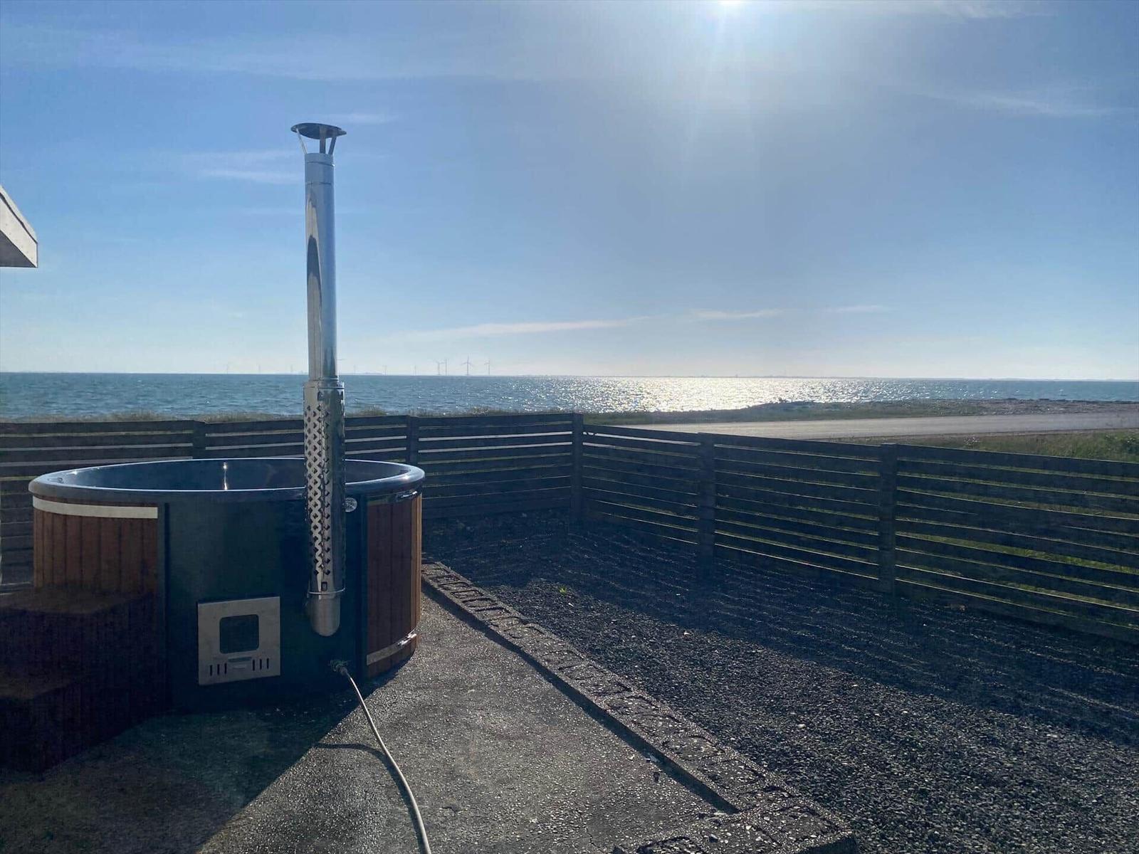 Hitzepool mit Meerblick und Windkraftanlagen im Hintergrund.