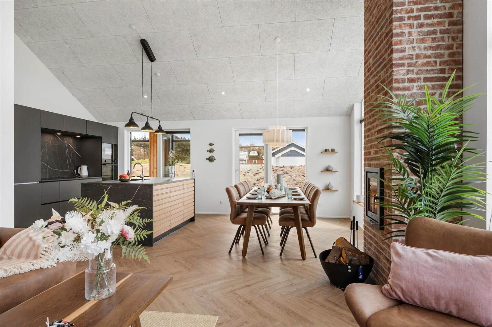 Moderne offene Küche mit Esstisch, Wohnbereich und Kamin.