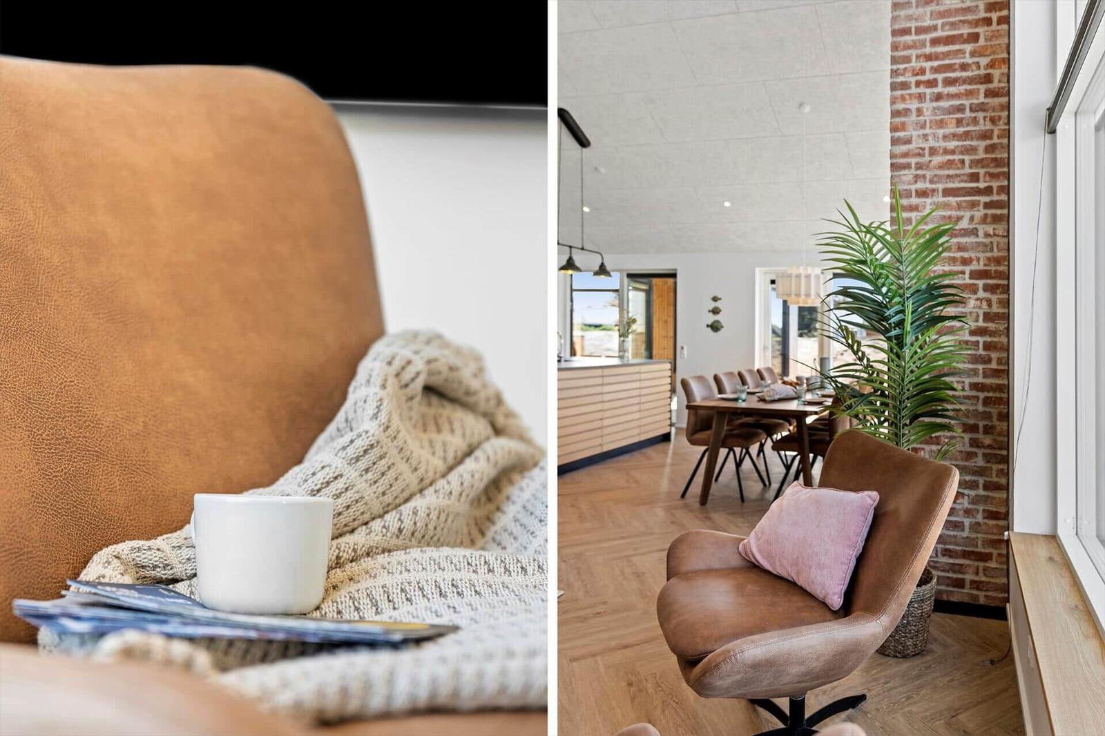 Ein braunes Sofa mit Decke und Tasse. Ein Sessel mit Kissen neben einer Pflanze.