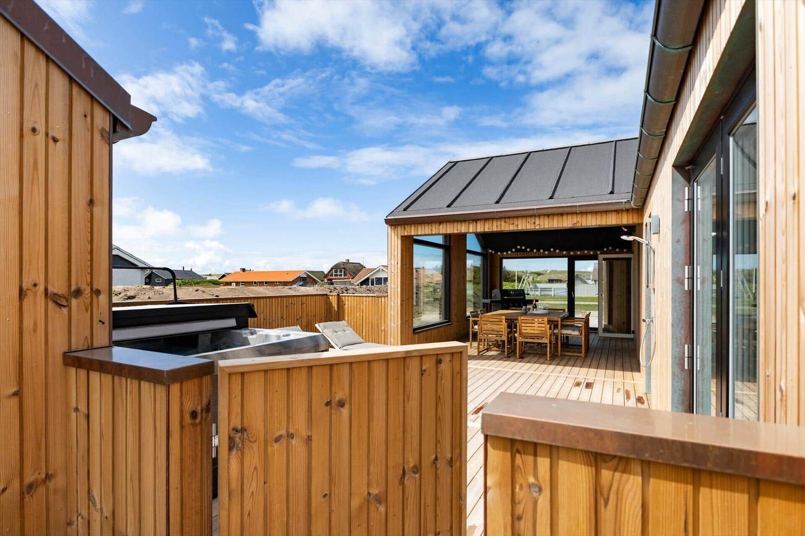 Terrasse mit Grill, Sitzgelegenheiten und Blick auf die Umgebung.