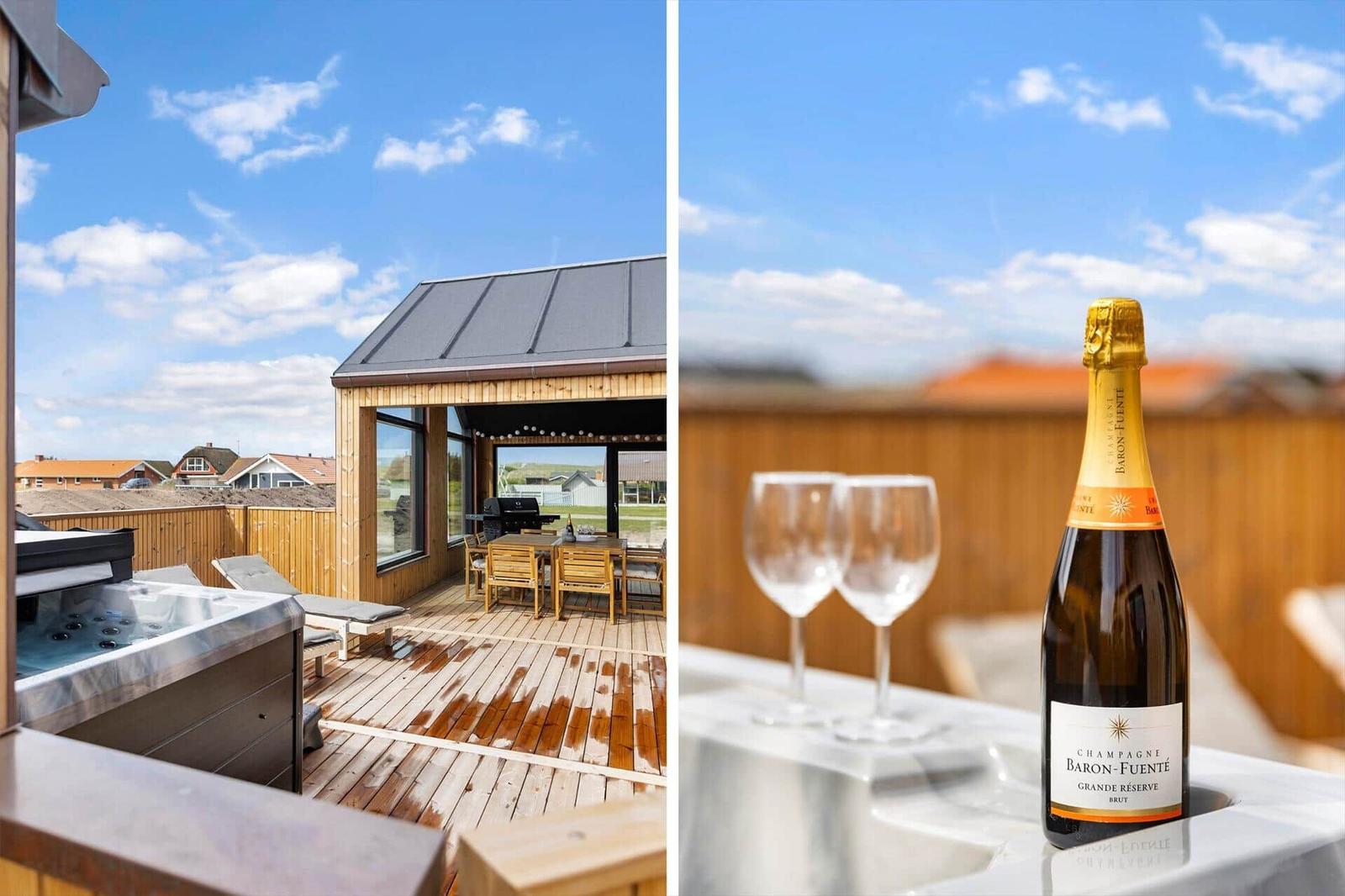 Terrasse mit Whirlpool, Grill und Sitzgelegenheiten. Flasche Champagner und zwei Gläser.