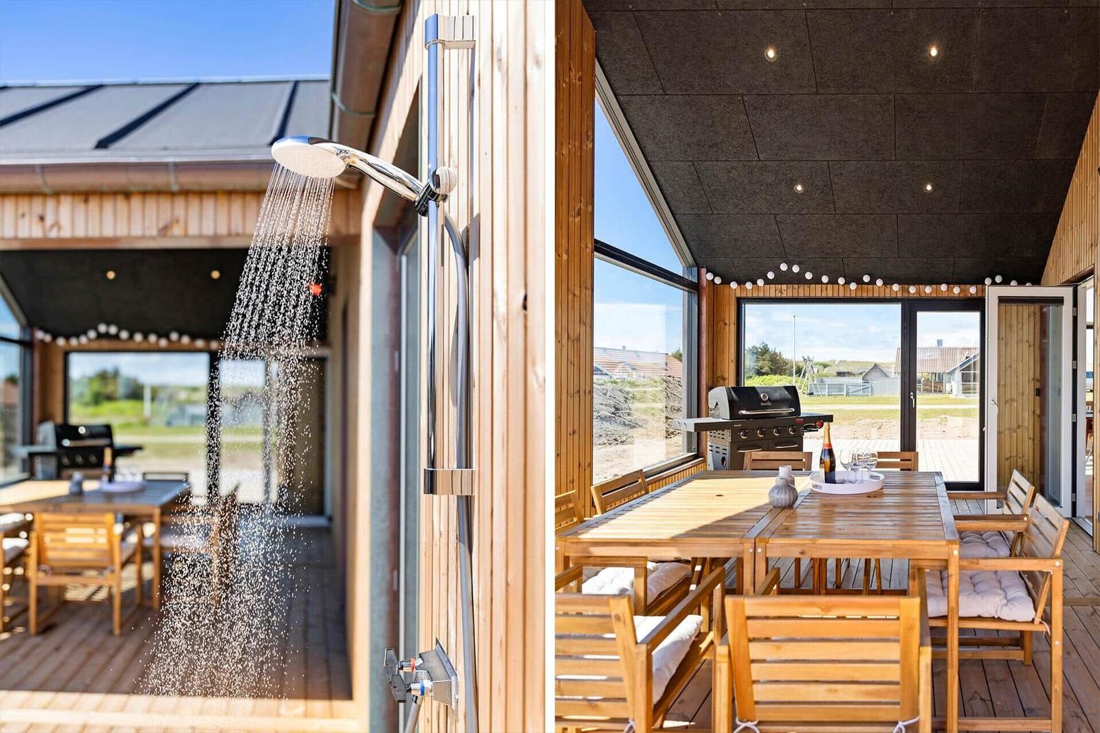 Außen-Dusche und großer Holztisch mit Grill und Sitzgelegenheiten.