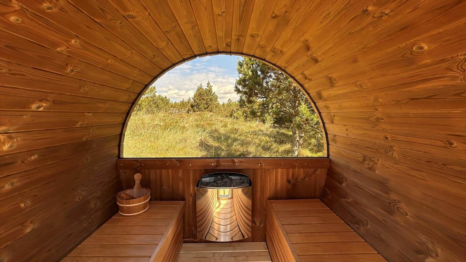 Sauna mit Holzwand und großem Bogenfenster auf Wald