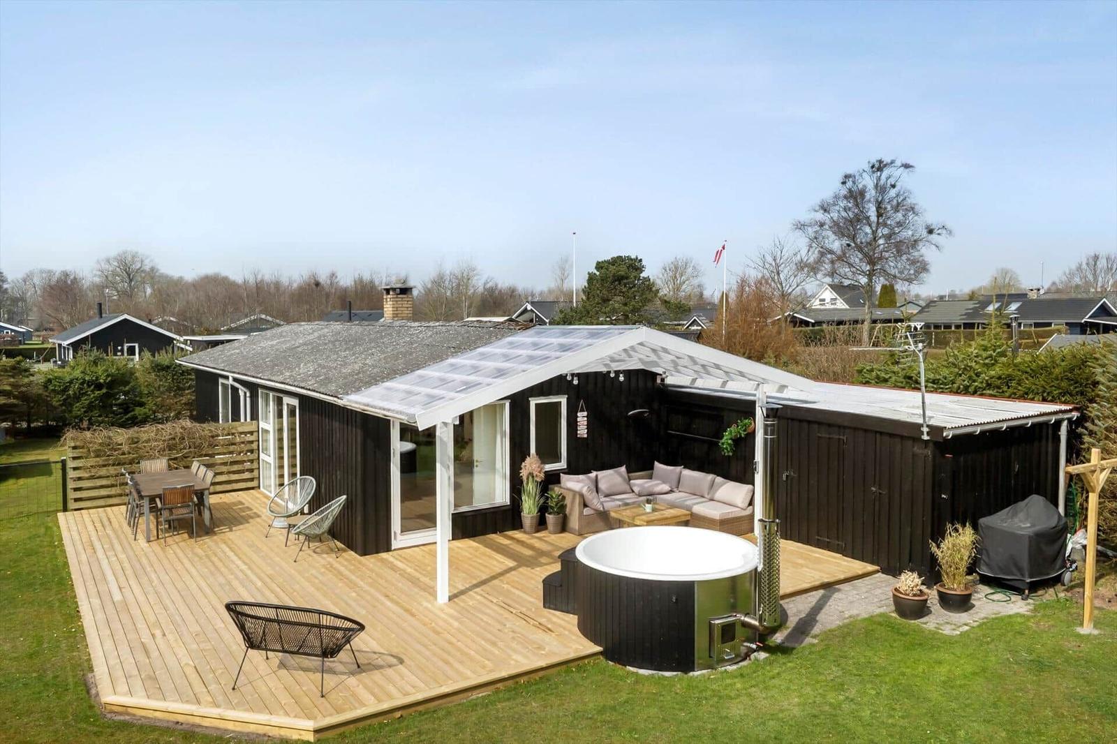 House with terrace, hot tub, and outdoor seating area.