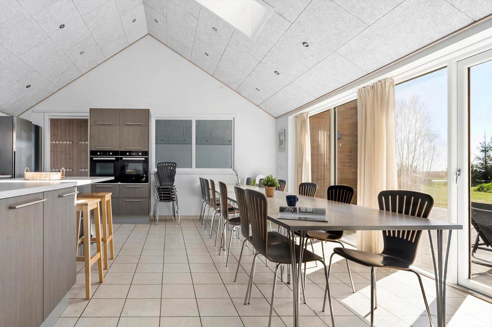 Moderne Küche mit Essbereich und großem Fenster zur Terrasse.