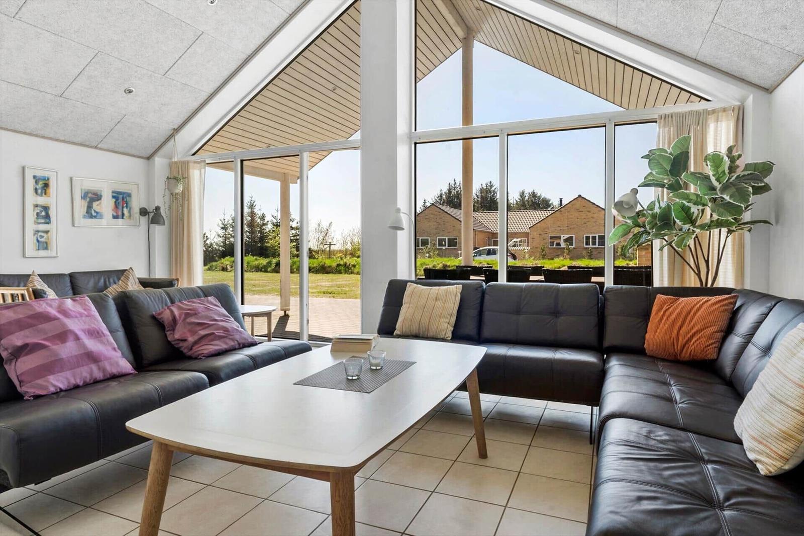 Living area with leather sofa, coffee table, and view of the garden.