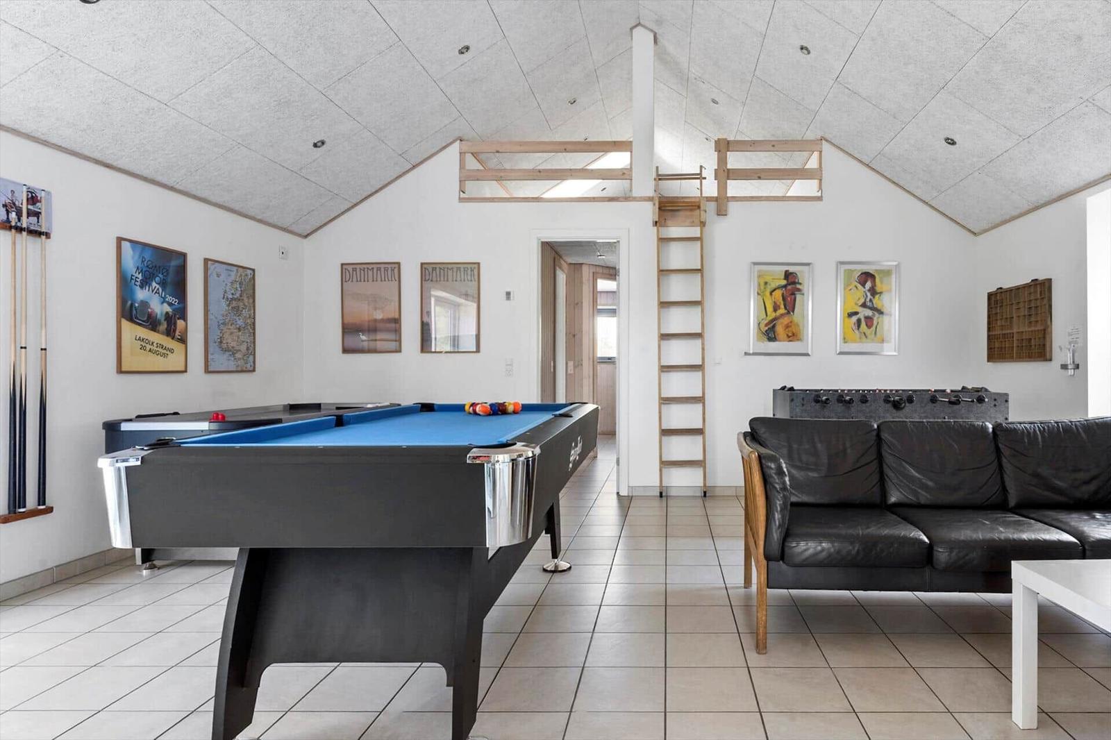 Room with pool table, sofa, and climbing frame under roof