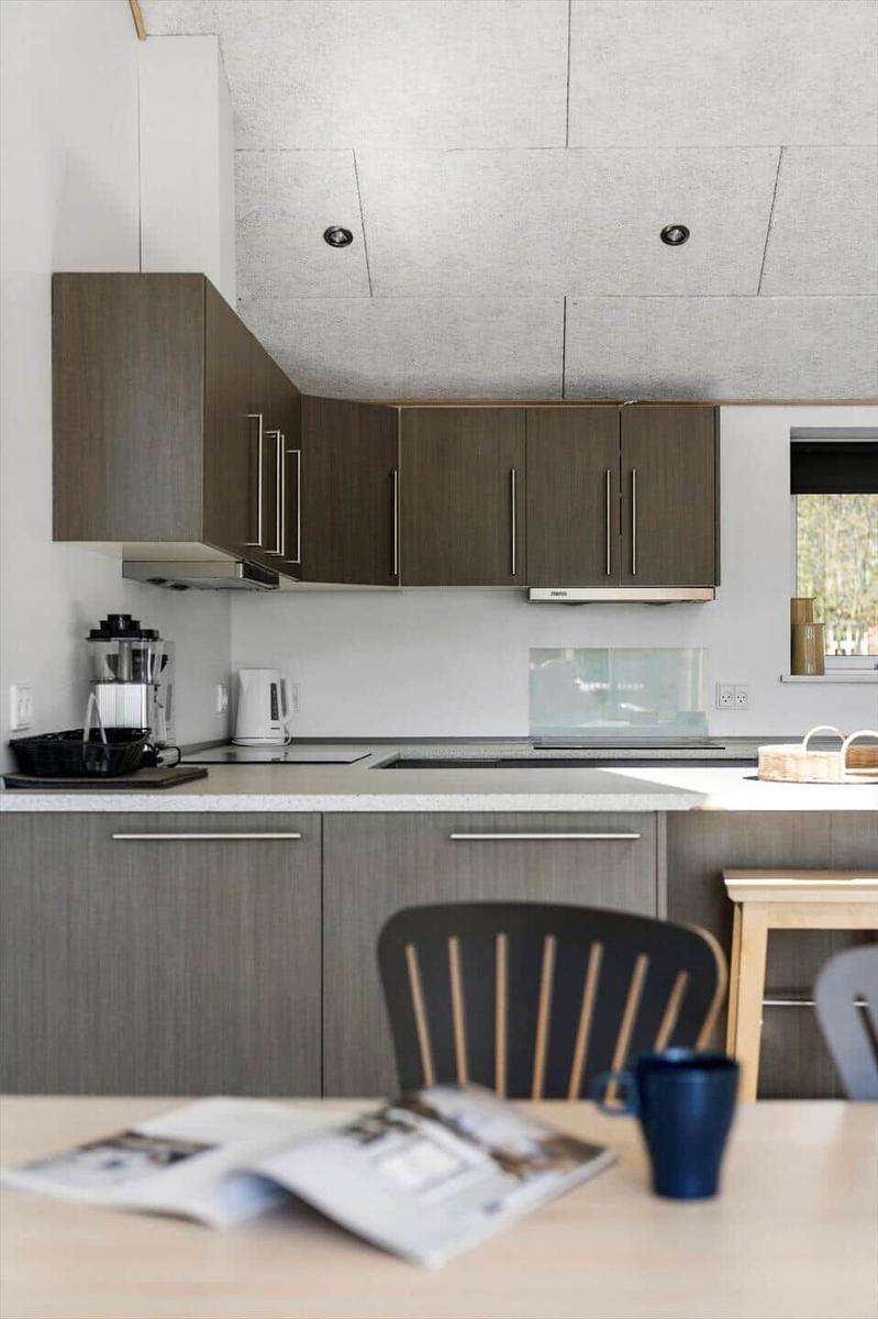Kitchen with wooden cabinets, stovetop, and dining table with chairs.