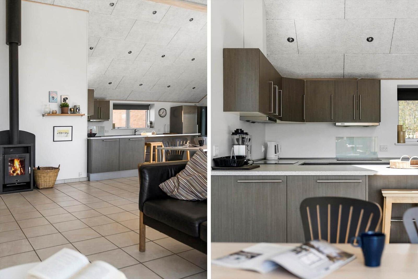 Living and kitchen area with fireplace, wooden table, and modern kitchen.
