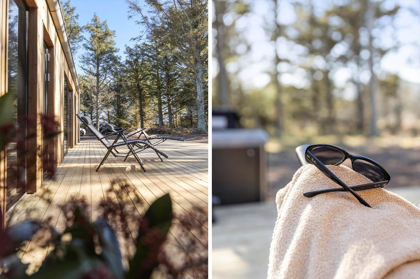 Holzterrasse mit Liegestühlen und Blick in den Wald. Sonnenbrille auf Handtuch.