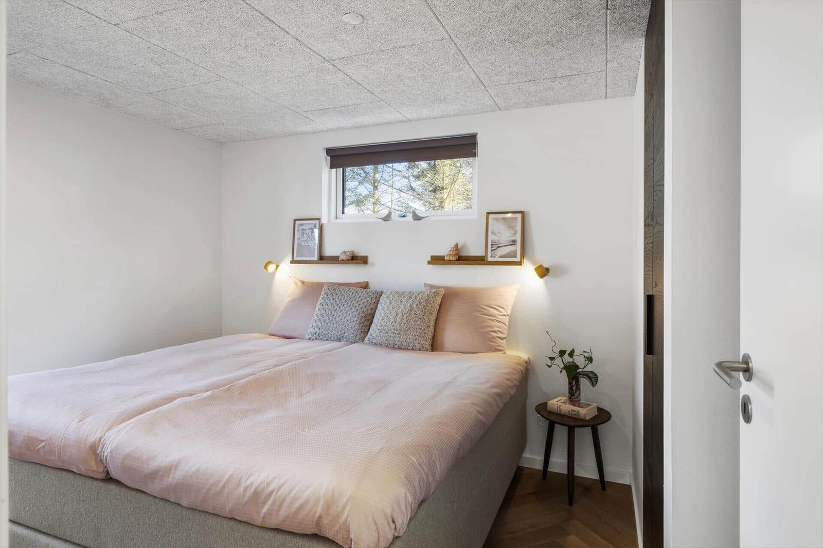 Schlafzimmer mit Bett, Fenster und kleinem Tisch