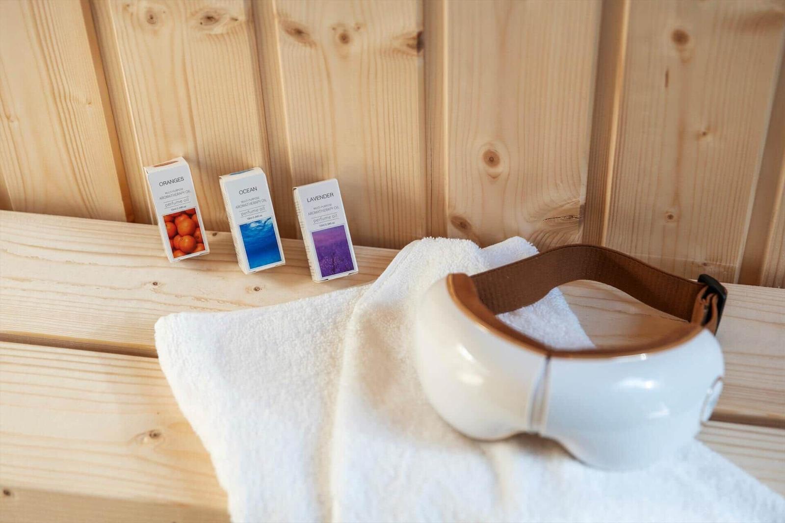 Massagegerät und Duftöle auf Holzbank