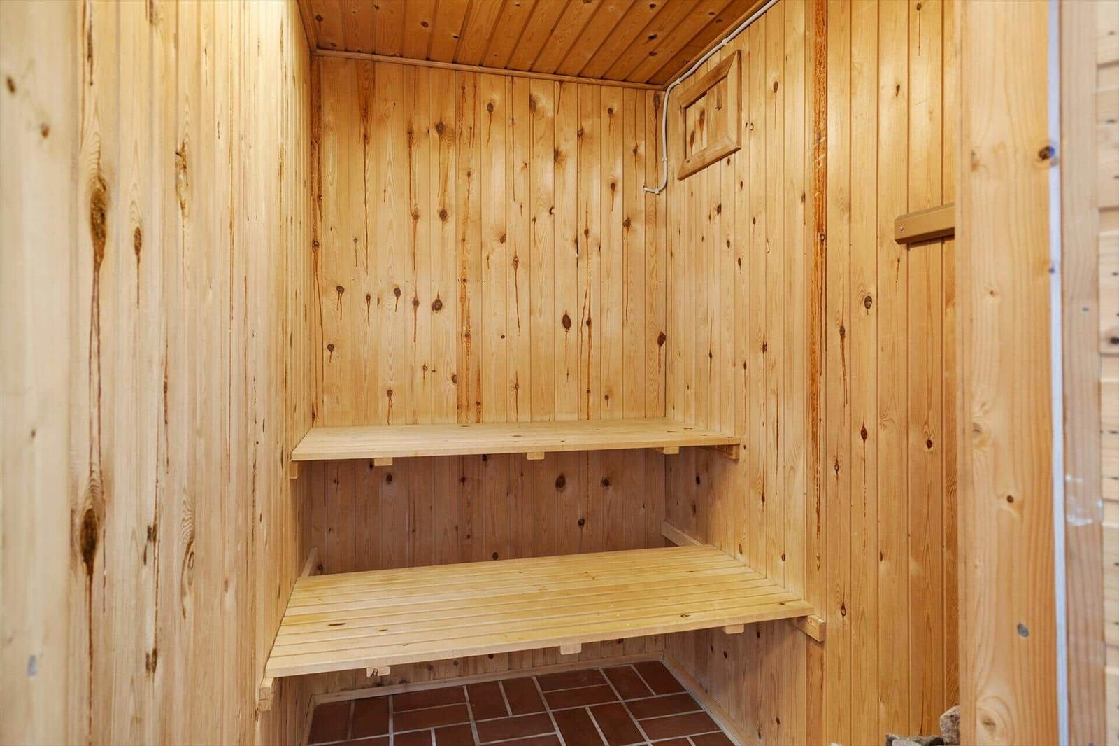 Sauna mit Holzwand und zwei Sitzbänken