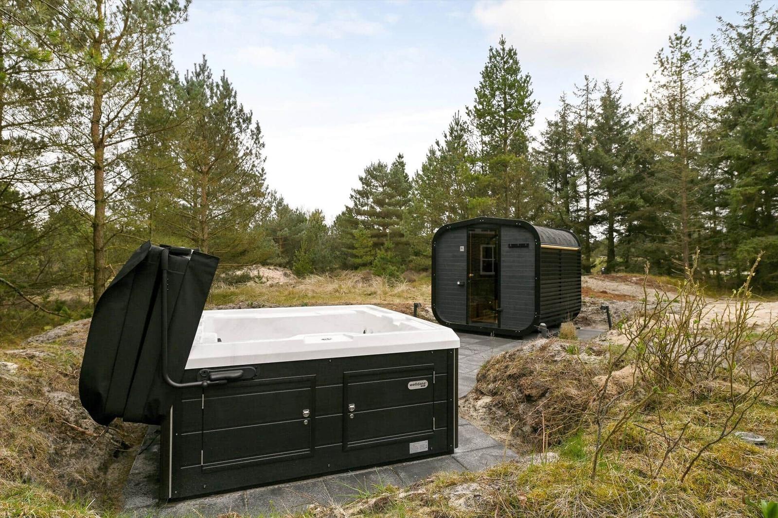 Ein Whirlpool und eine Sauna stehen im Wald.