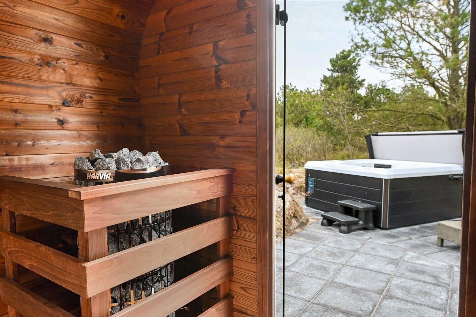 Sauna mit Harvia-Steinbecken und Blick auf Whirlpool im Freien.