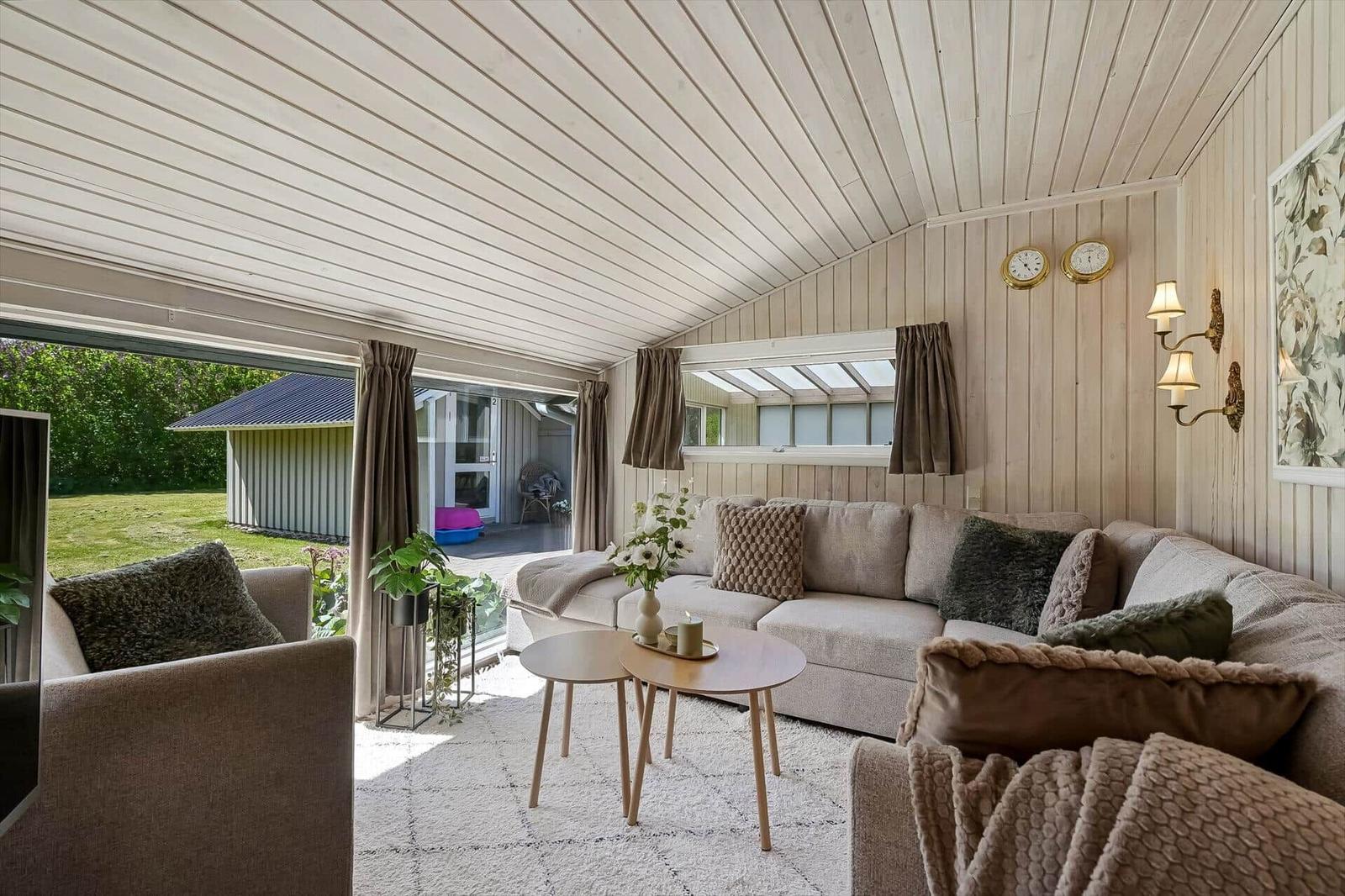 Wohnzimmer mit Sofa, Tisch und Blick auf Garten.