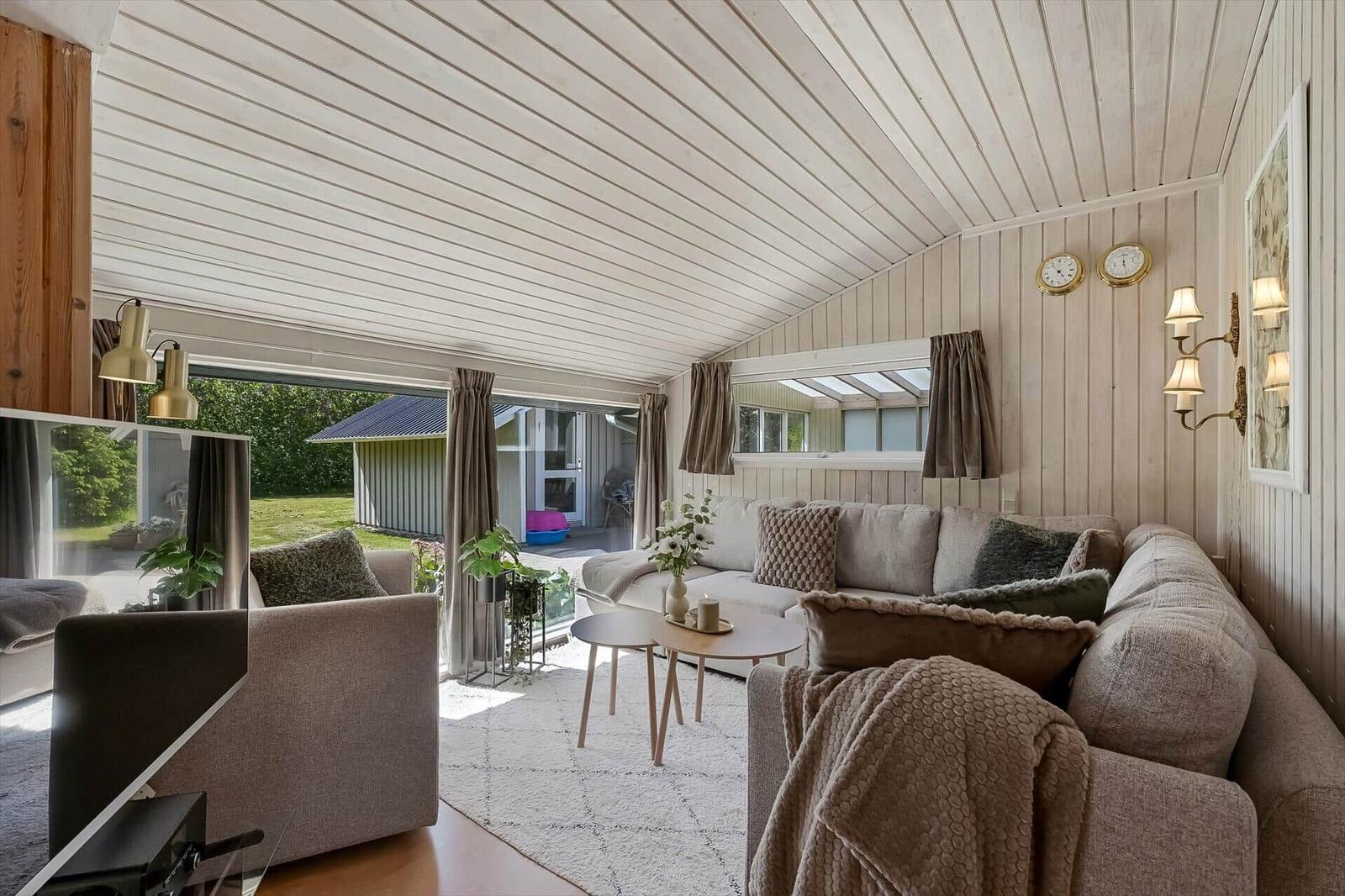 Wohnzimmer mit Sofa, Tisch und Blick auf Garten