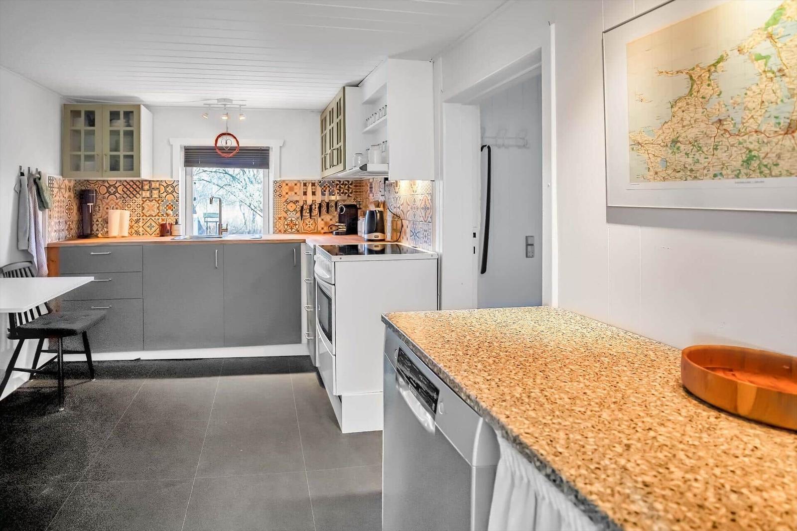 Kitchen with countertop, refrigerator, and tile backsplash