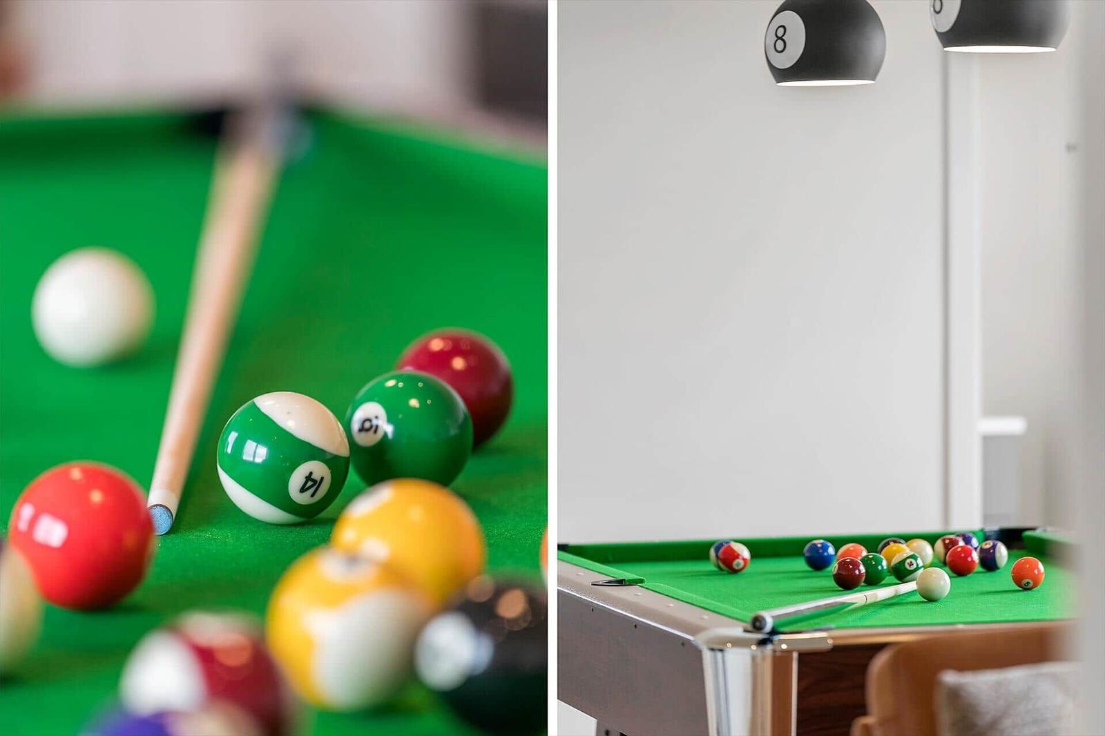 Pool table with colored balls and cue on green felt.