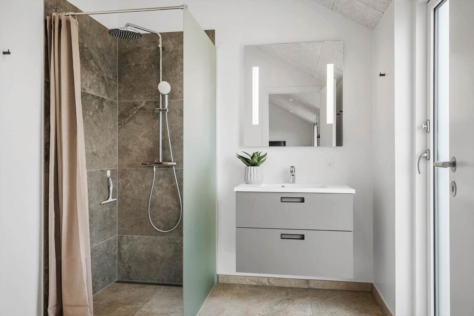 Bathroom with shower, sink, and mirror