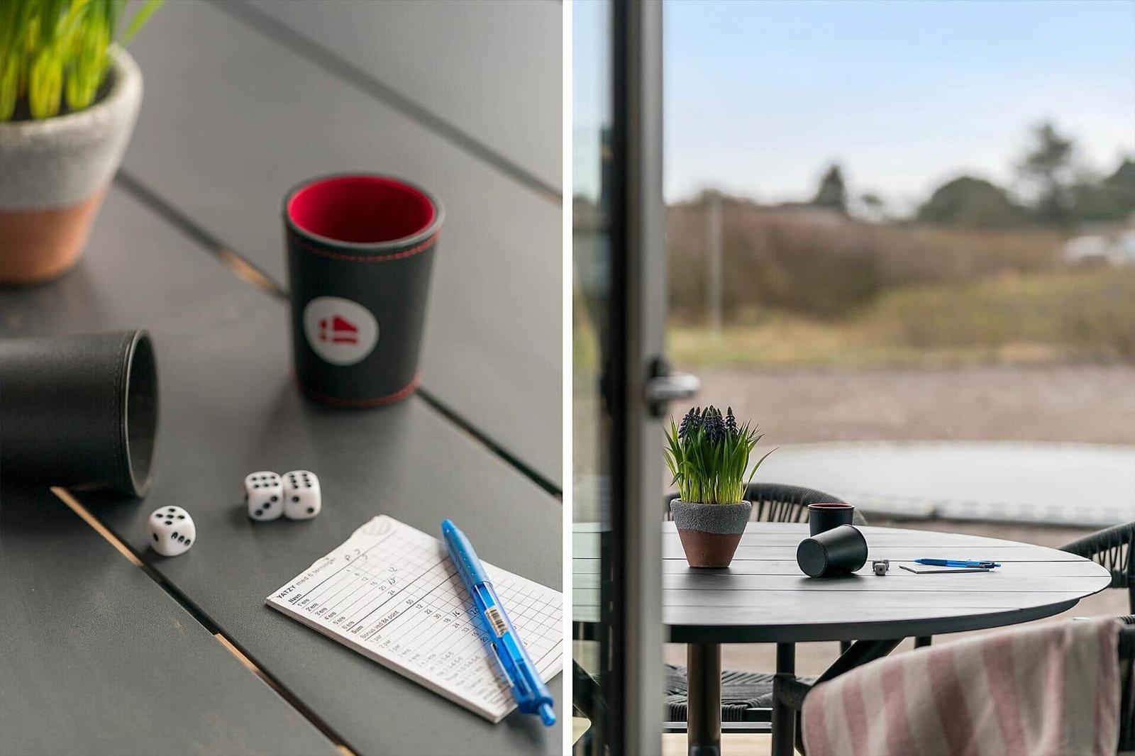 Table with dice, cup, and notepad outdoors.