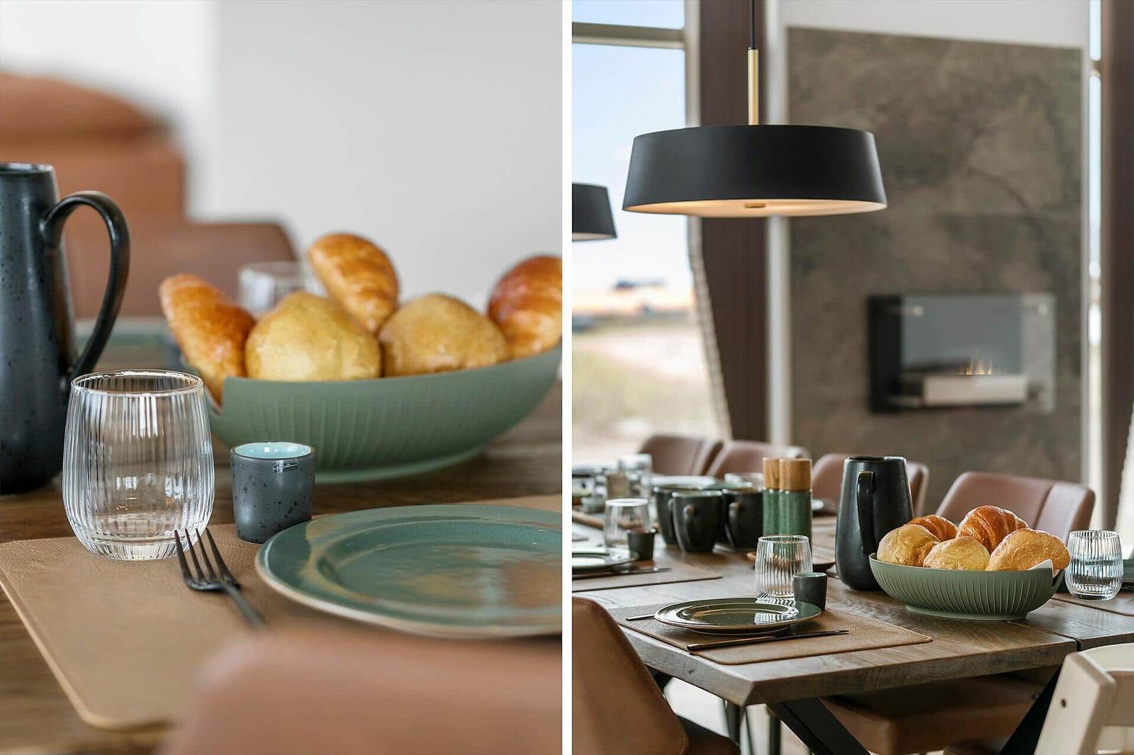 Dining table for multiple people, ceramic bowl with bread rolls, modern pendant light.