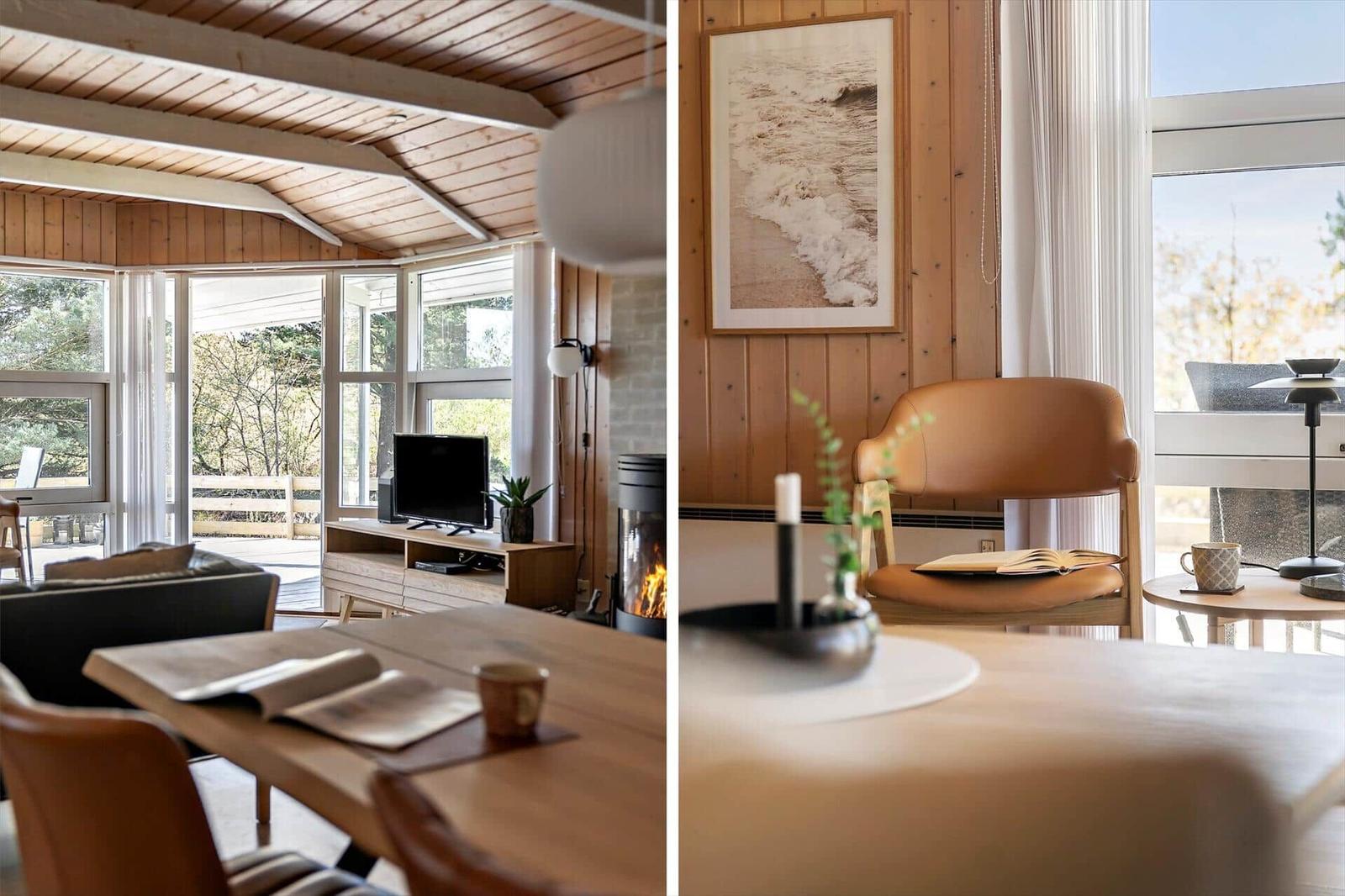 Wohnraum mit Holzdecke, Kamin und großem Fenster. Nebenraum mit Stuhl, Tisch und Wandbild.