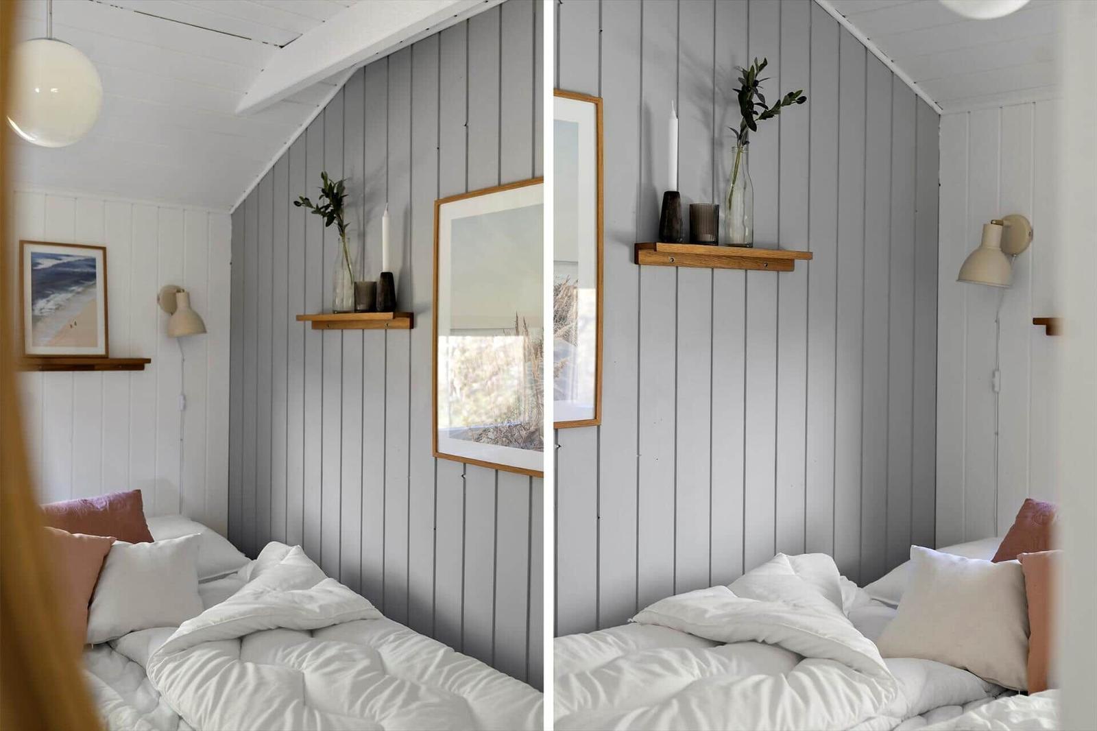 Schlafzimmer mit Bett, Wandregal und Bild an grauer Holzwand.