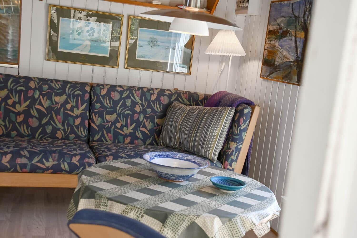 Ein Sofa mit gemustertem Stoff und ein Tisch mit Tischdecke und Schalen.