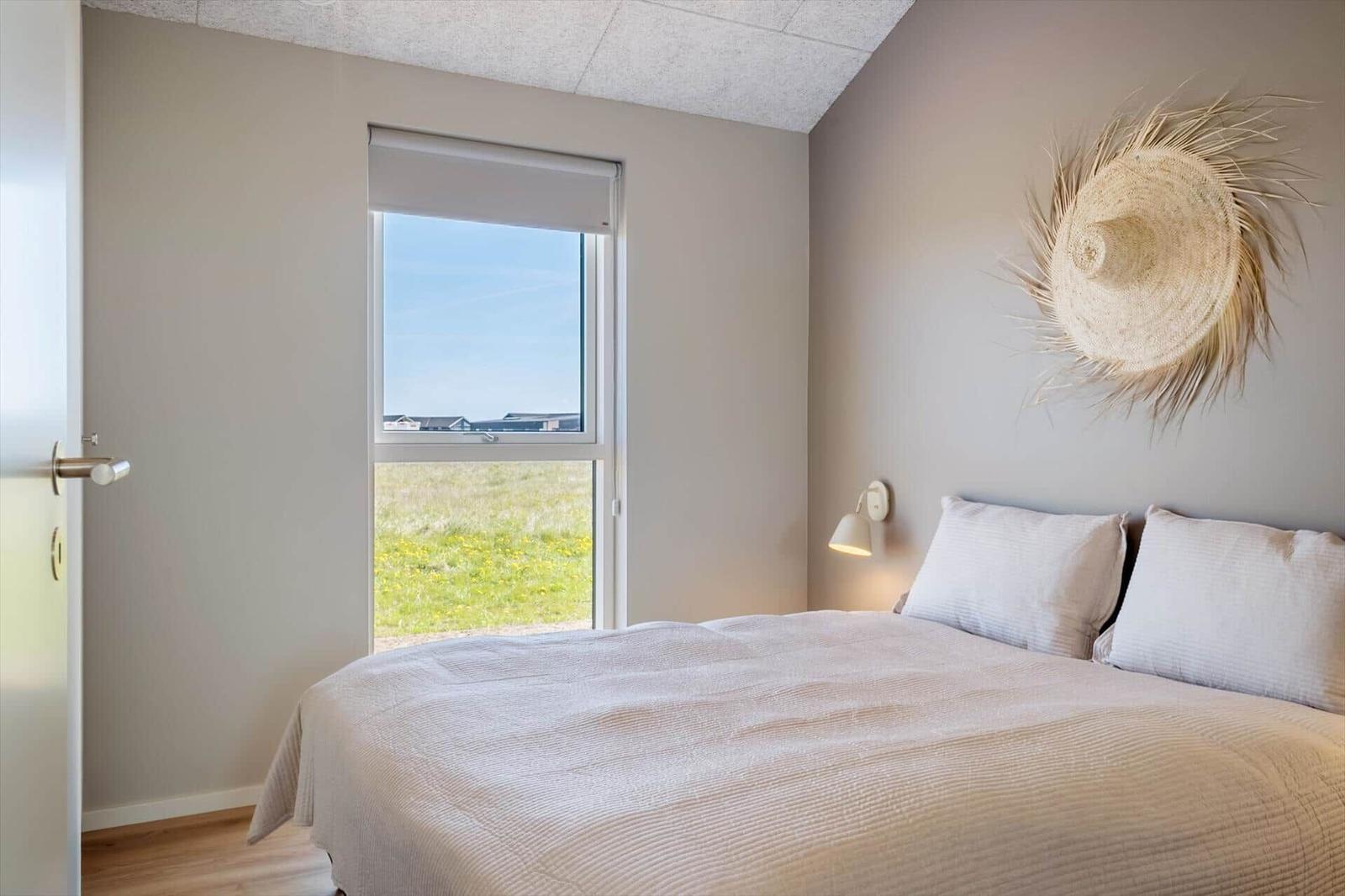 Schlafzimmer mit Bett, Fenster und Wanddekoration