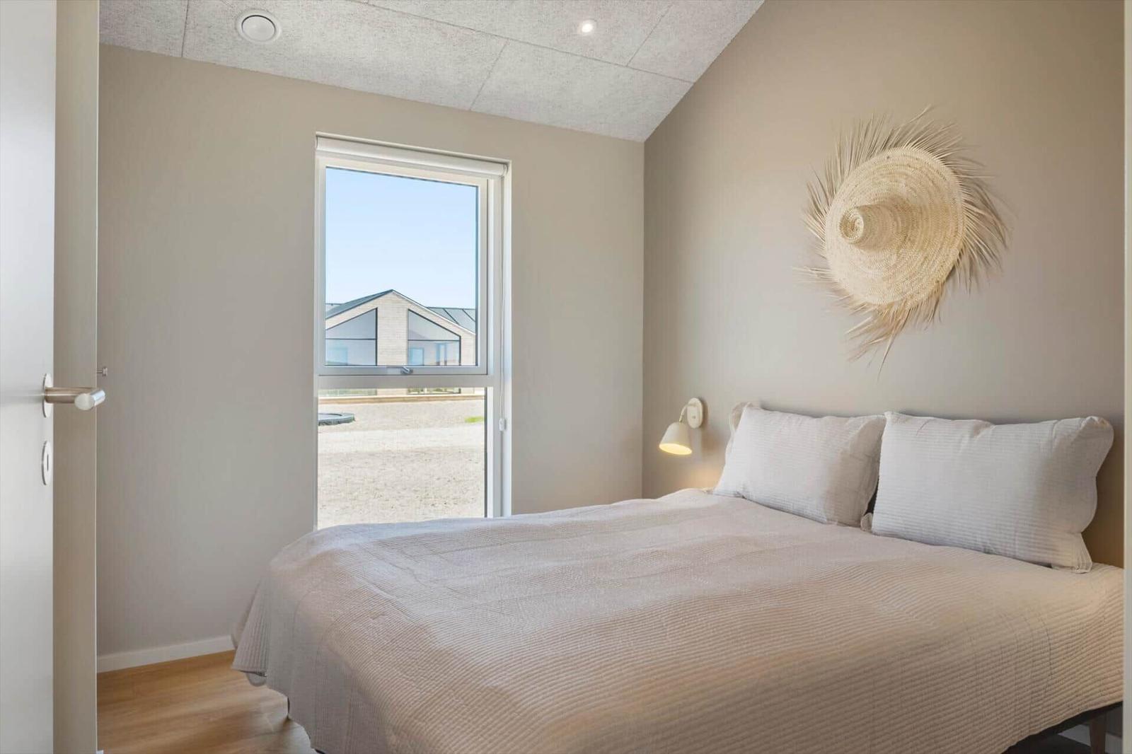 Schlafzimmer mit Bett, Fenster und Wanddekoration