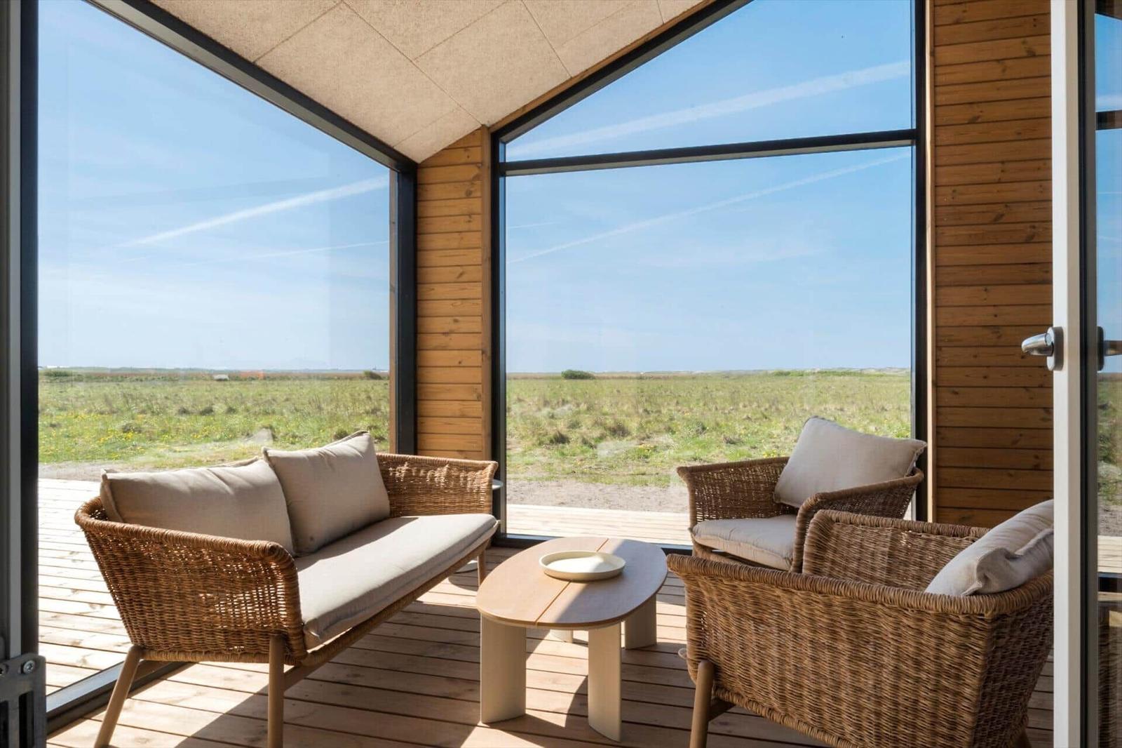 Terrasse mit Sitzgelegenheiten und Blick auf eine grüne Landschaft.