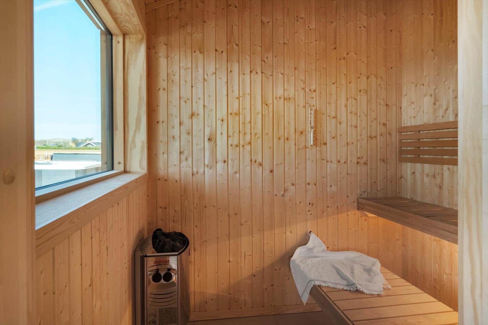 Sauna mit Holzwand, Sitzbank und Fenster mit Aussicht