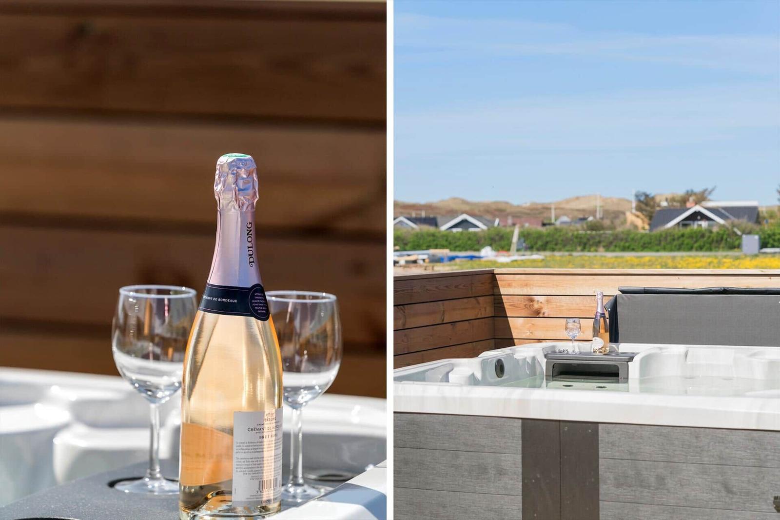 Eine Flasche Sekt und zwei Gläser auf einer Whirlpool-Plattform mit Blick auf die Landschaft.