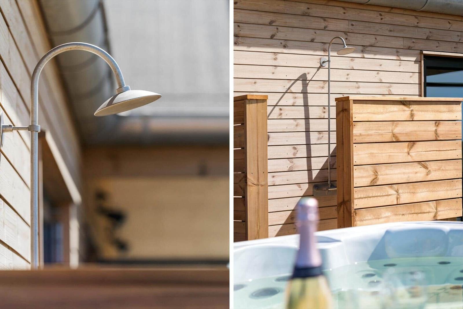 Außen-Dusche an Holzwand. Whirlpool mit Flasche im Vordergrund.