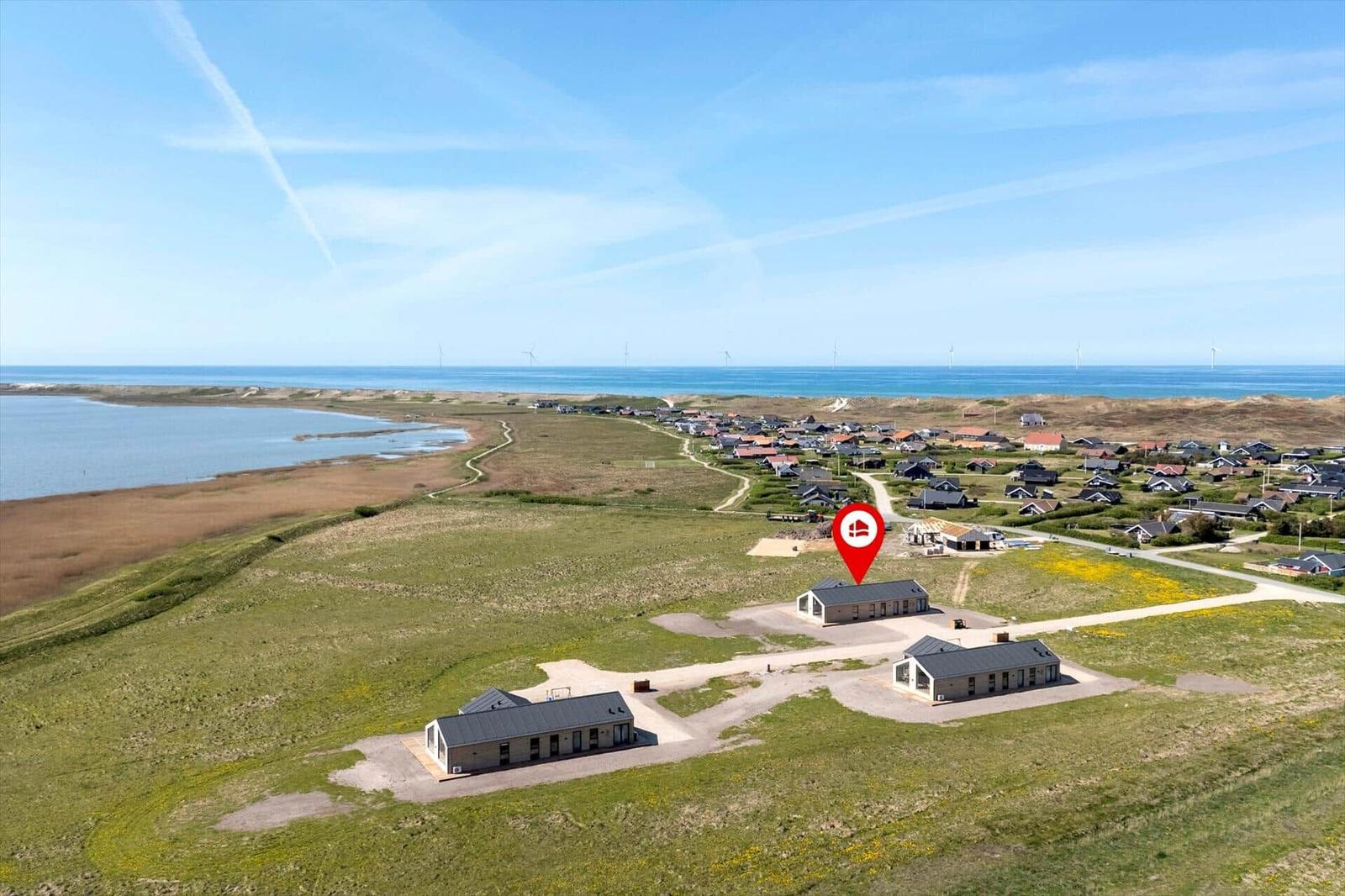 Modernes Ferienhaus mit Blick auf Meer und Windkraftanlagen