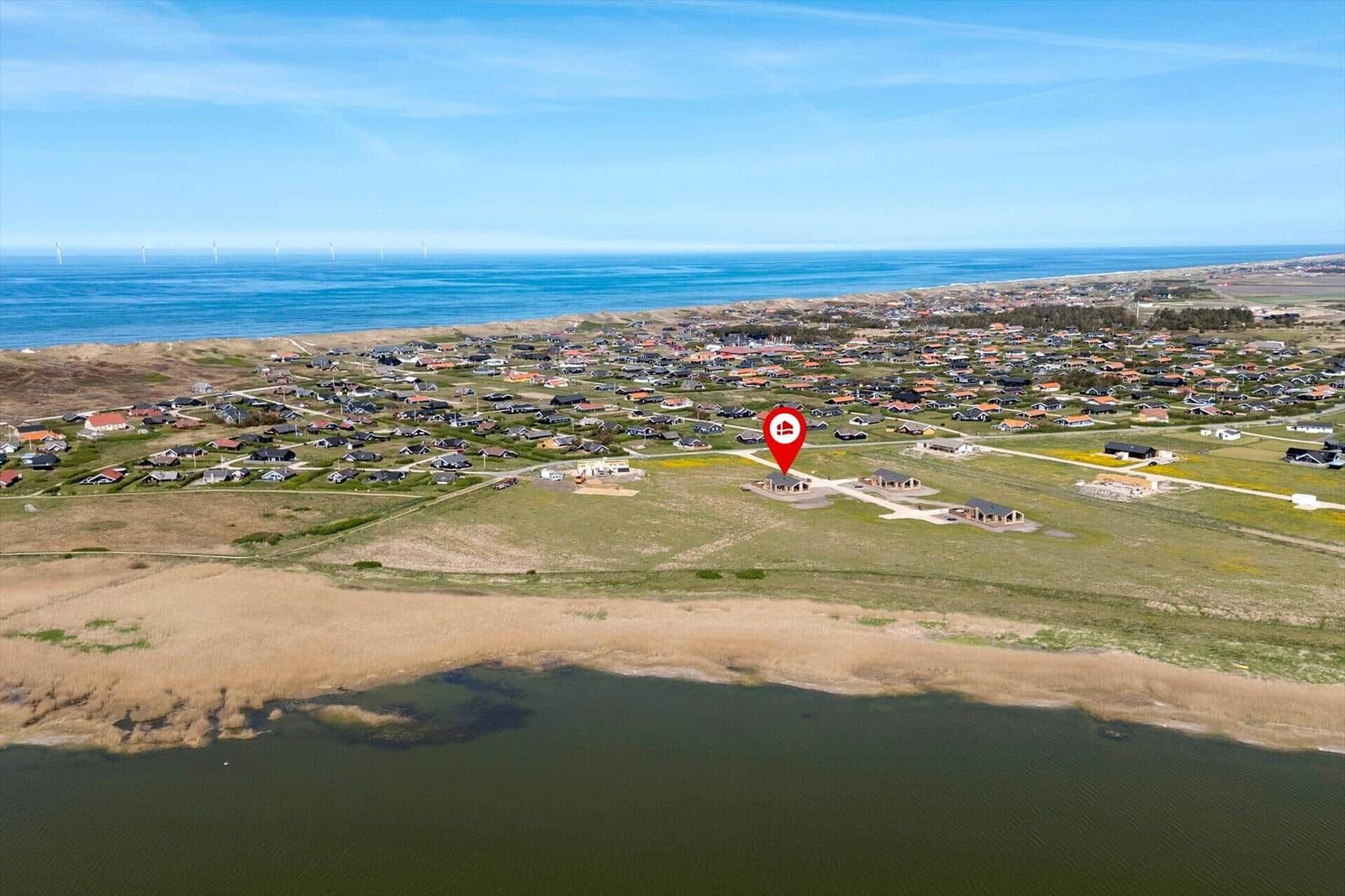 Luftbild von Ferienhaus mit Blick auf Meer und Windkraftanlagen