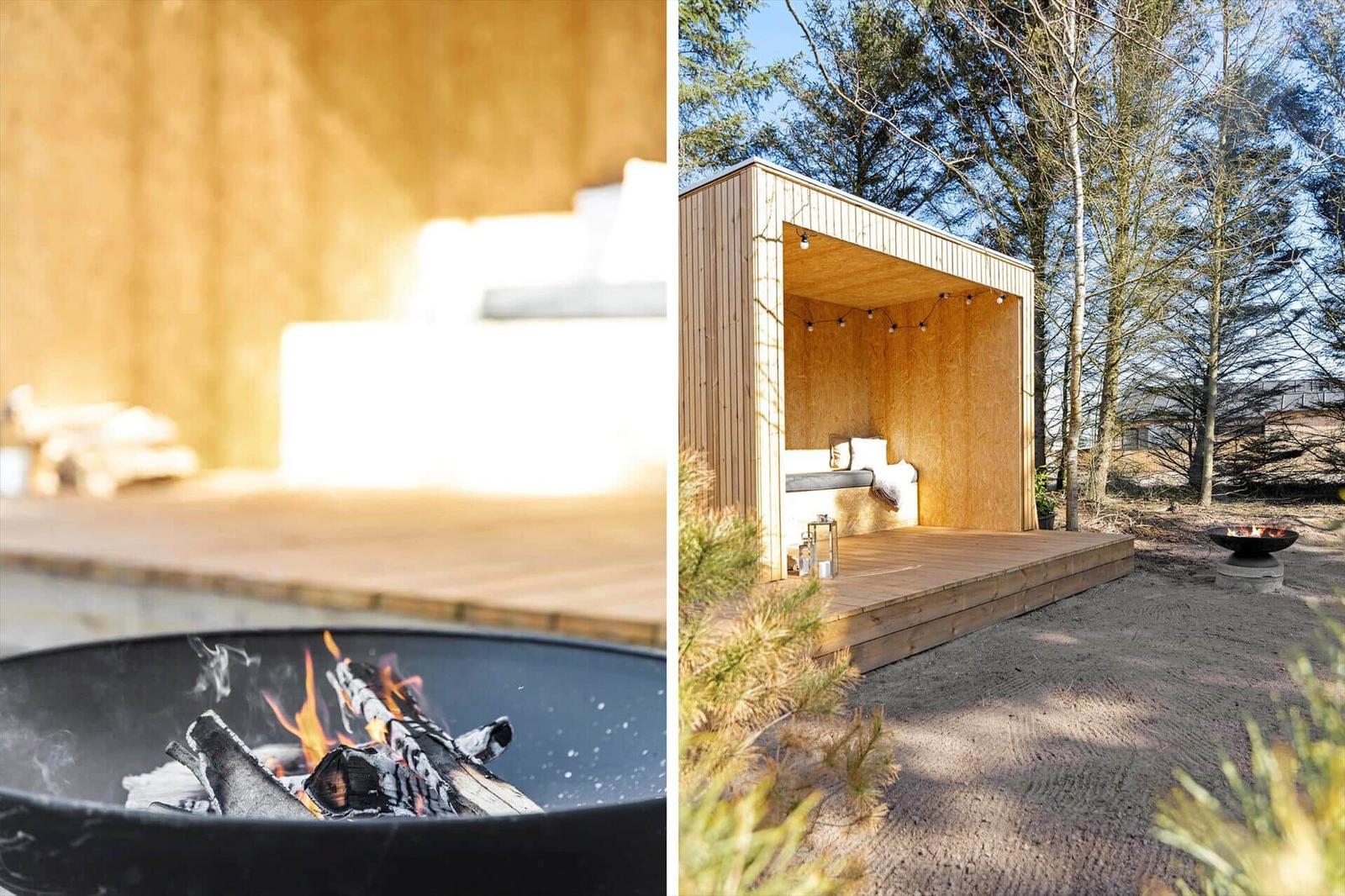 Holzkonstruktion mit Sitzbank und Feuerkorb im Freien