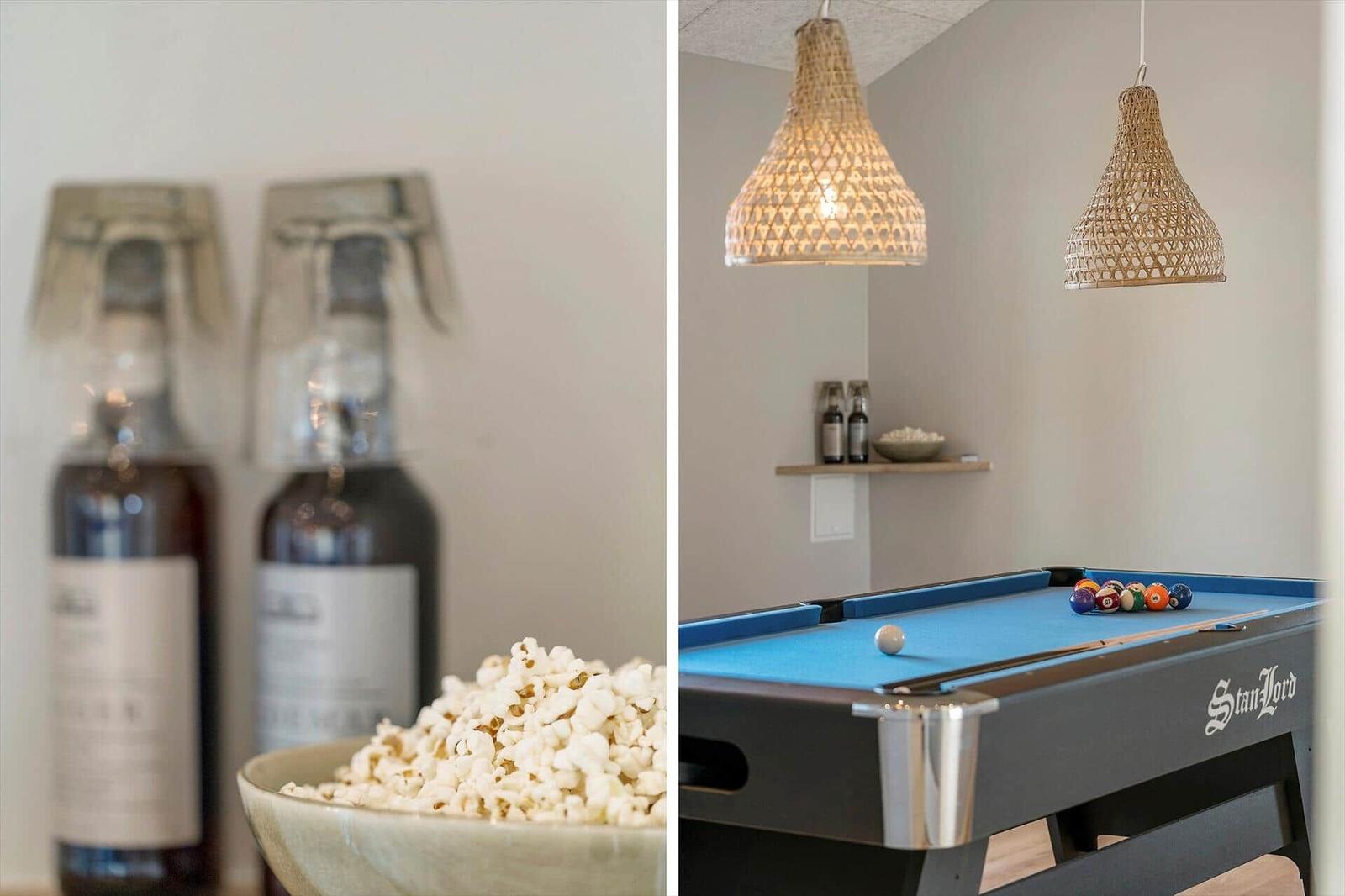 Pooltisch mit blauem Tuch und Körbchen. Hängende Lampen und Flaschen im Hintergrund.