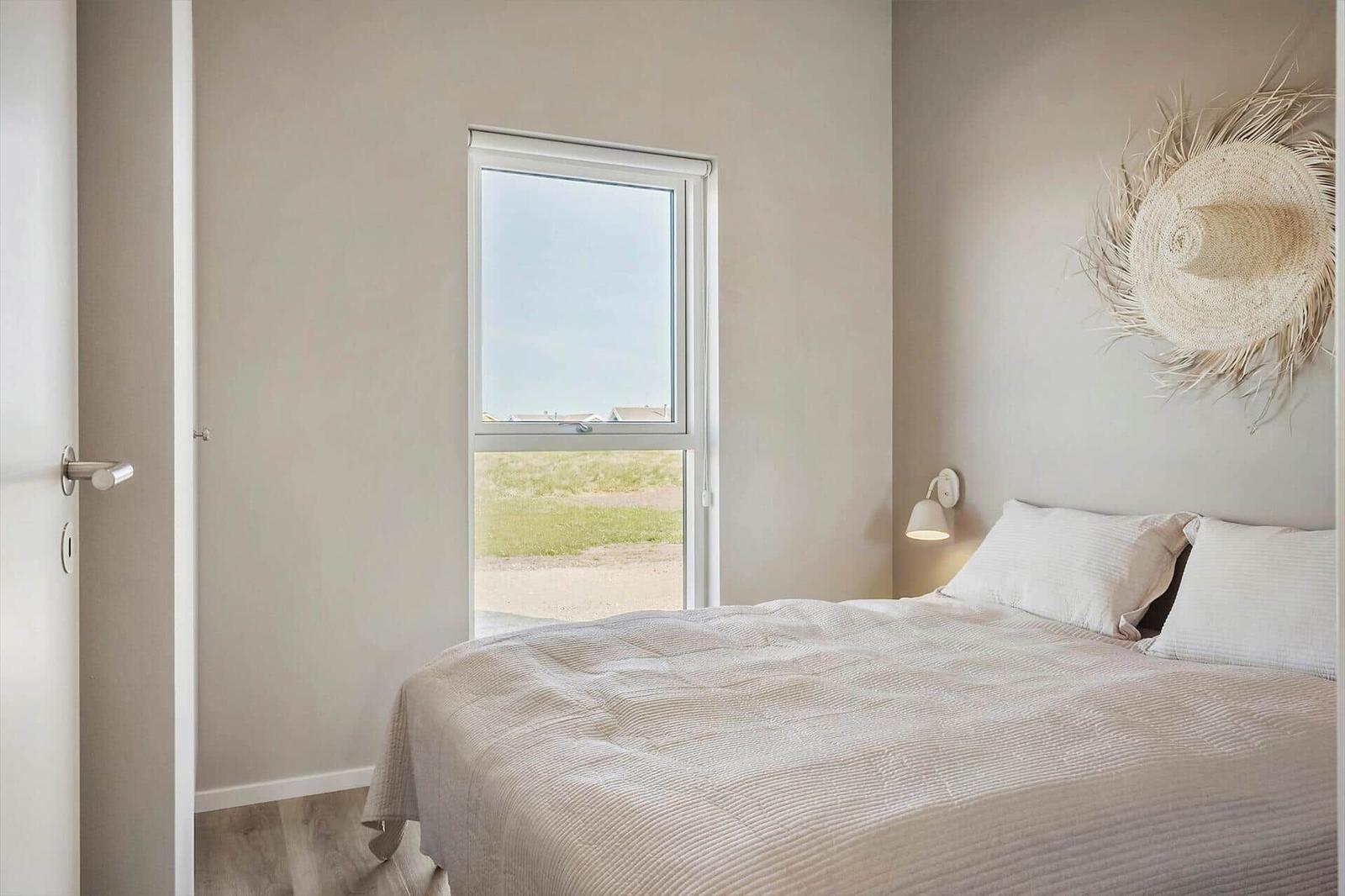 Schlafzimmer mit Bett, Fenster und Wanddekoration