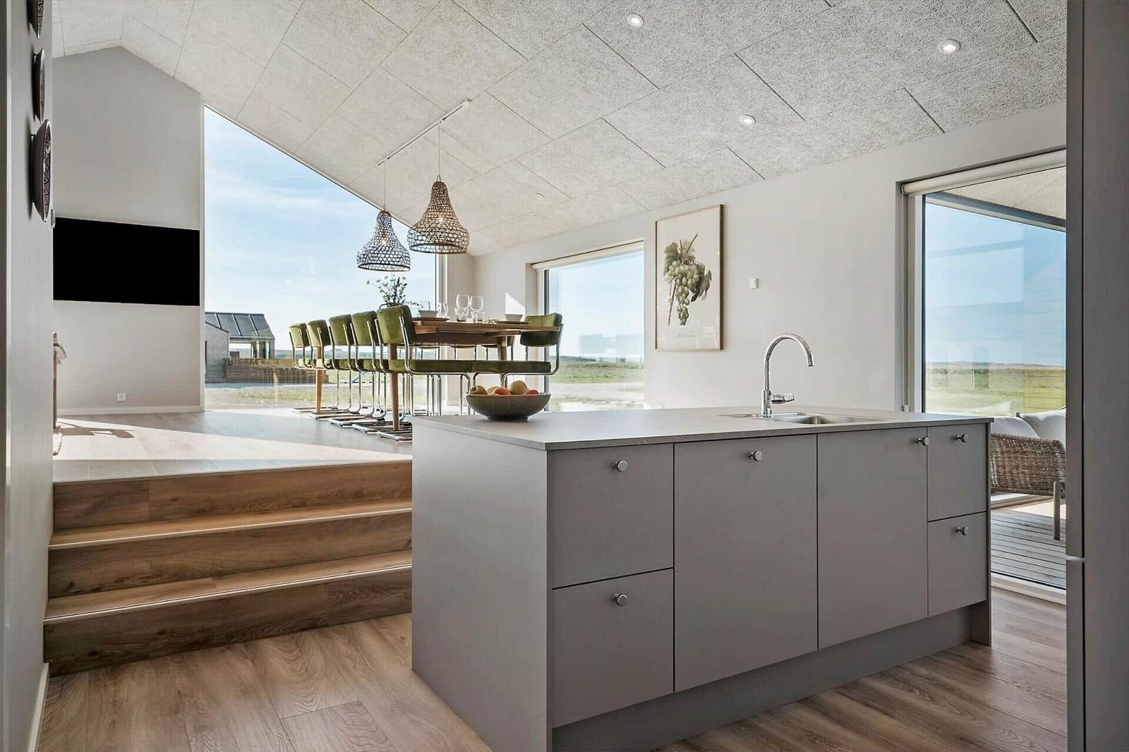 Küche mit Insel, Sitzgelegenheit und großem Fensterblick.