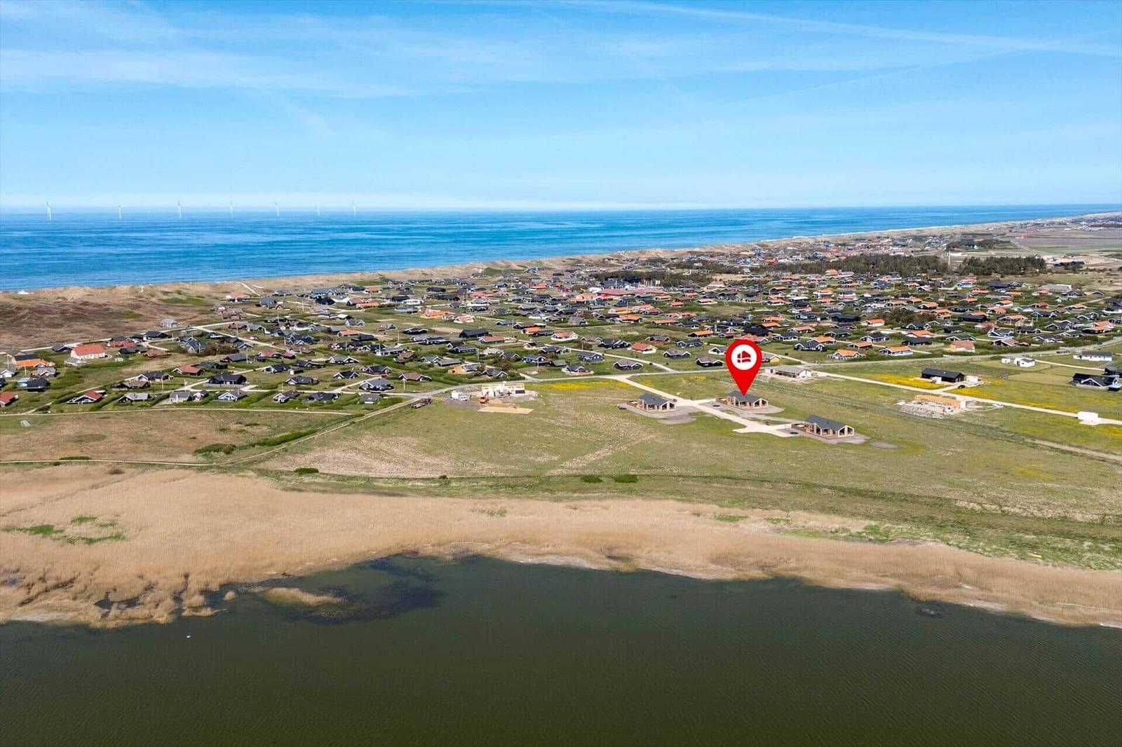 Luftbild von Strandhaus mit Blick auf Meer und Windkraftanlagen