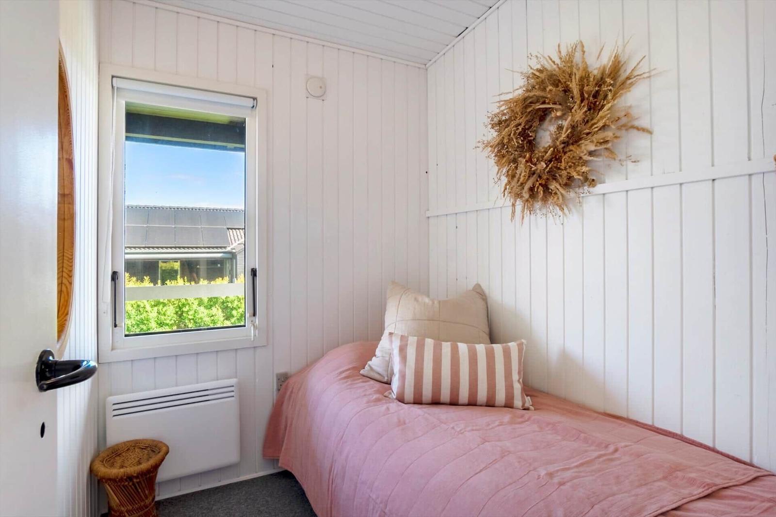 Ein Schlafzimmer mit Bett, Fenster und Wanddekoration.