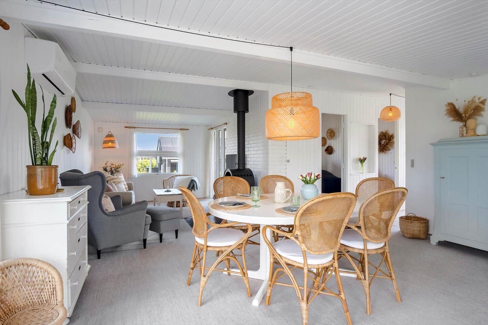 Esszimmer mit runden Tisch und Stühlen, Wohnbereich mit Sessel und Kamin.