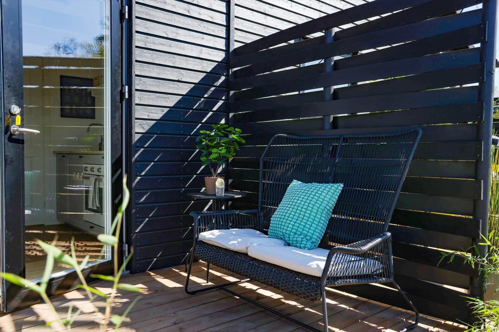 Deck with bench, plant, and view into the kitchen.