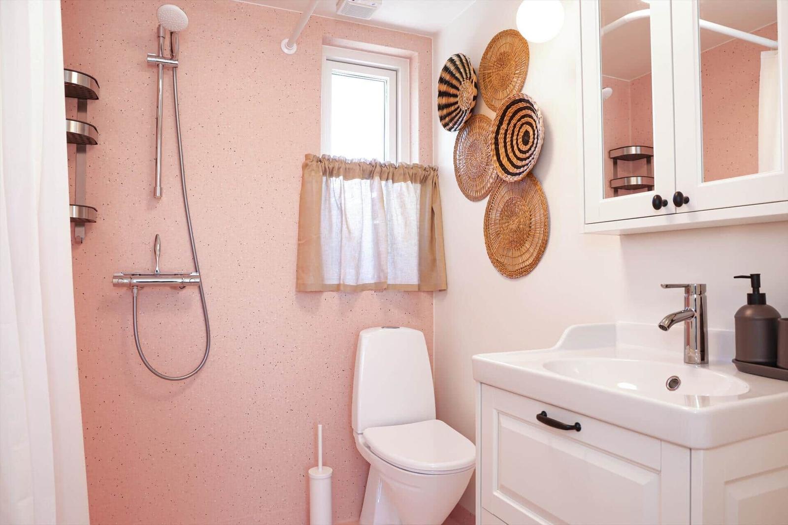 Bathroom with shower, toilet, and sink. Wall decoration of woven baskets.