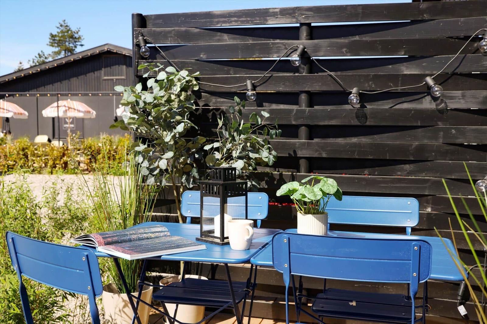 Blue table and chairs with plants and lighting in the garden.
