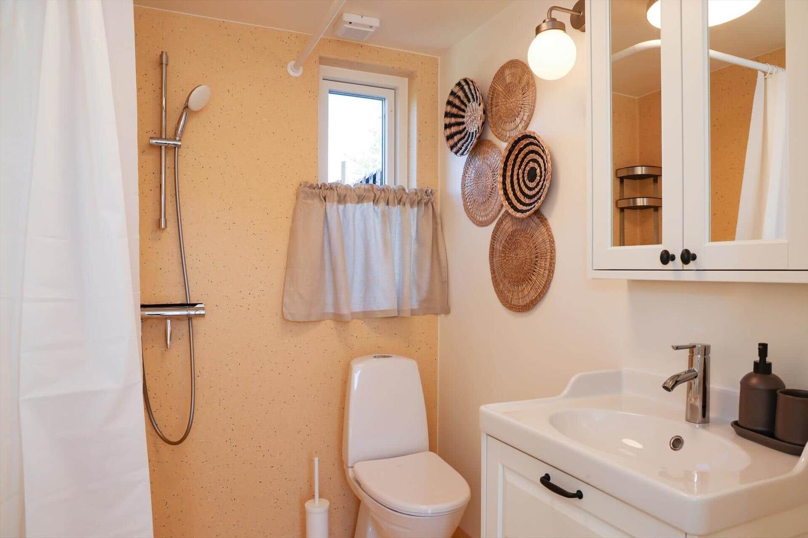 Bathroom with shower, toilet, and sink. Wall decoration with woven baskets.